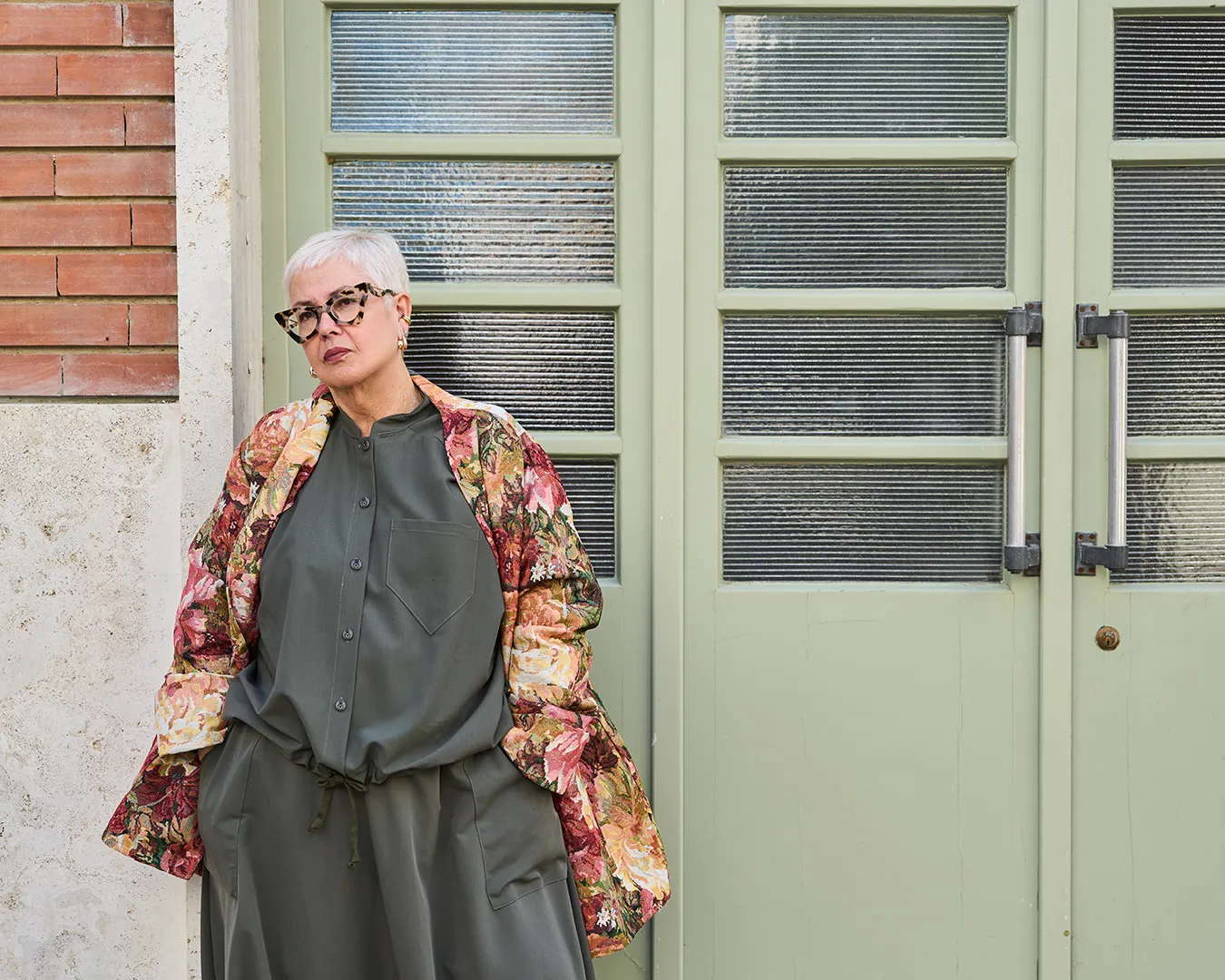 PERIOPOLIS campaign: floral jacket in front of the green doors of the former Manifattura Tabacchi